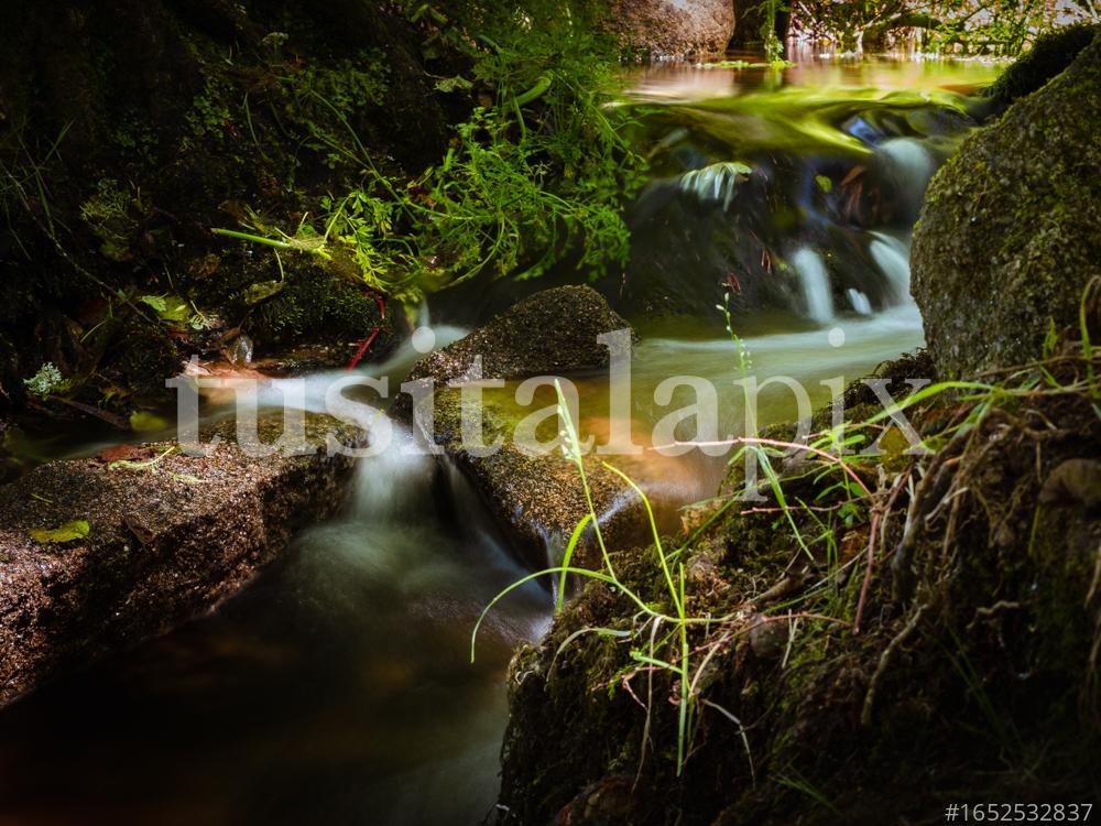 Agua del río cae sobre las piedras